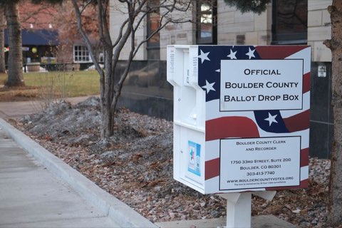 A metal ballot drop box on a sidewalk.